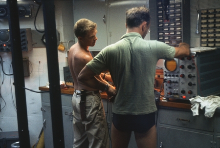 Unidentified lab technicians of the Swan Song Expedition (1961) are shown here setting the electronic TDS meter on board t...