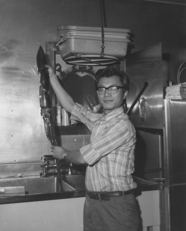 Man holding up a squid on board the D/V Glomar Challenger (ship) during one of the legs of the Deep Sea Drilling Project. ...