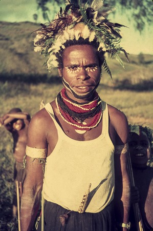 Young man with an improvised headdress, face paint, shell valuables and other adornments