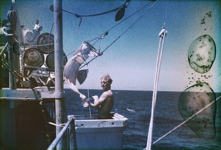 Deane Carlson is shown here with plankton net in the bucket on the R/V Horizon during the MidPac expedition. 1950.