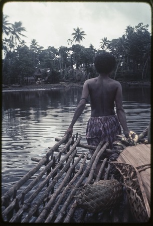 Kaiyabai&#39;i pulls her canoe in shallow water to Tukwaukwa village, Kiriwina