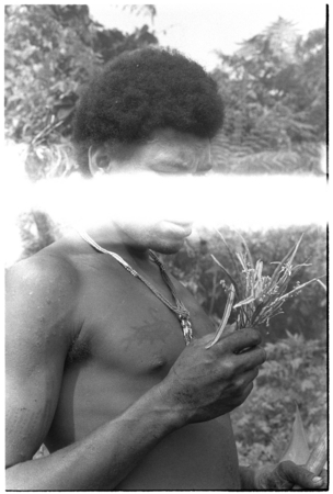 Man performing divination with knotted cordyline leaves