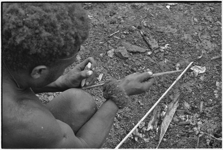 Carving: stone tool being used to smooth an arrow