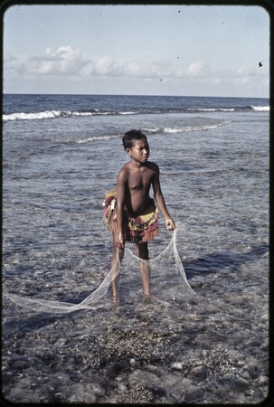 Fishing: girl holds small net on the fringing reef near Wawela village, Library Digital Collections
