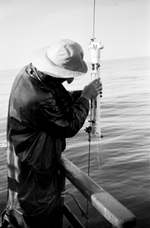 A crewmember using a Nansen bottle for seawater sampling aboard R/V E.W. Scripps