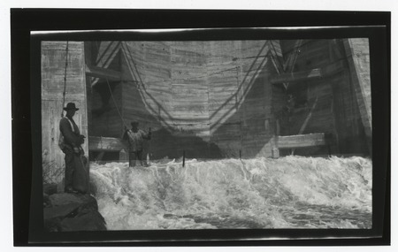 Men catching fish in net from spillway on Lake Murray Dam