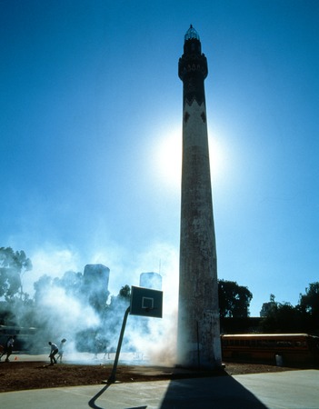 MUEZZIN: general view with sun behind minaret and smoke from fog machines rising