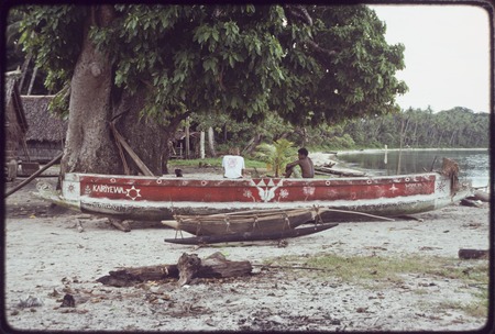 Canoes on the beach at Wawela village, including red-painted kula canoe with &quot;Kairiyewa&quot; written on the side