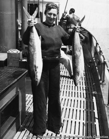Mrs. Arthur Flenner holding up catch of fish on boat