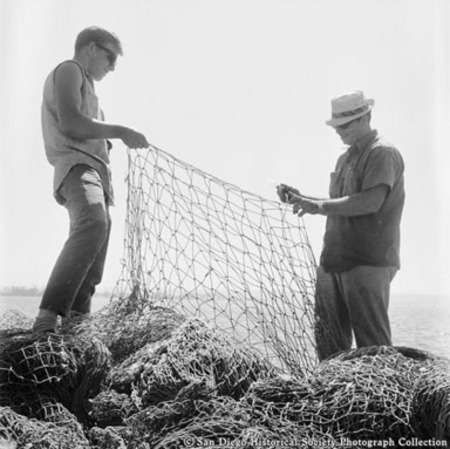 Two men inspecting fishing net