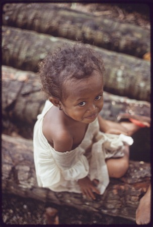 Young girl, Imala, sitting on some logs