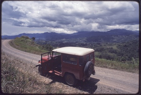 Western Highlands: jeep on an unpaved road, mountains in background