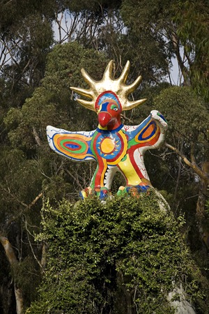 Sun God: detail view of sculpture and top half of vine-covered arch
