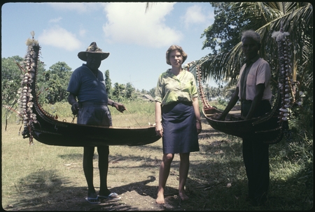 Frances Harwood with two men and miniature canoes