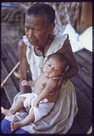 Bomtavau holds young infant, probably a grandchild