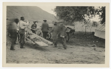 Men with carts near tent