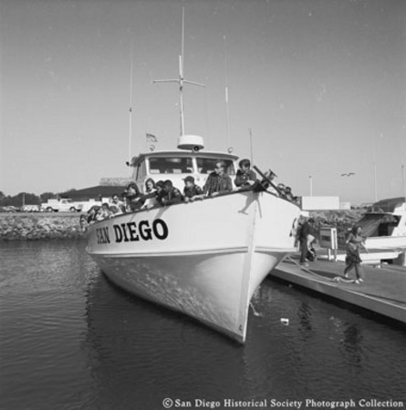 People on whale watching tour boat [San Diego?] moored to dock