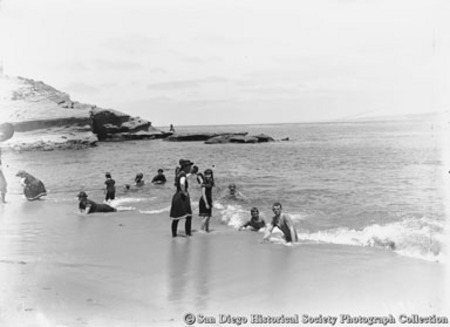 People in ocean surf at La Jolla Cove beach