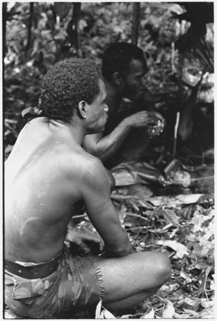 Men eating the ritual pudding.