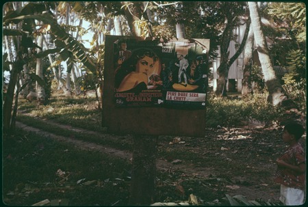 Movie posters on signboard beside a dirt road, Society Islands