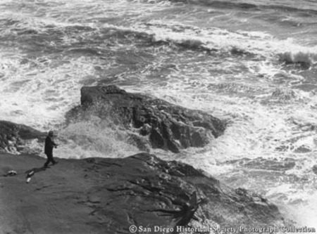 Man surf fishing from cliff on San Diego coast