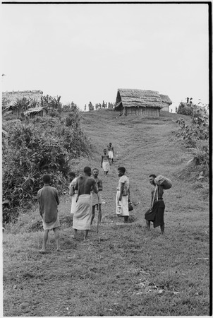 Megiranu, Wanuma Census Division: carriers on trail near houses