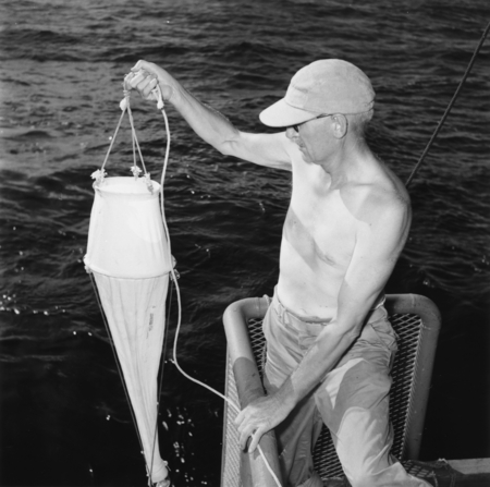 Martin W. Johnson holds a plankton net during the Capricorn Expedition