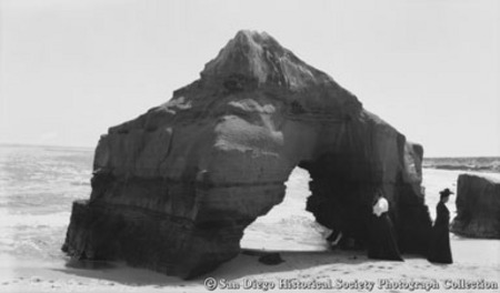 Woman standing near Cathedral Rock on La Jolla shore