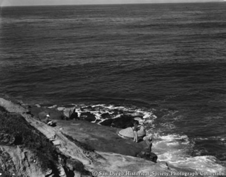 View from above of two men fishing from rocks on La Jolla coast