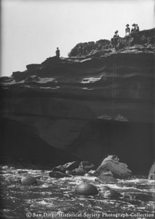 People standing on top of cliff near rope ladder, Sunset Cliffs