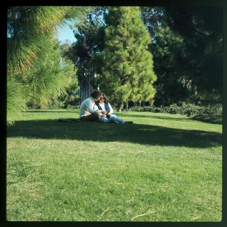 Two students sitting on grass