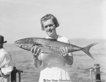 Woman holding fish caught from fishing barge Point Loma