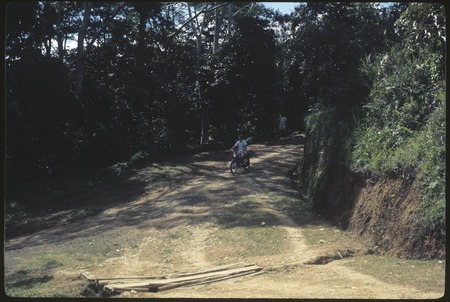Tabibuga, person riding motorcycle on road to airstrip