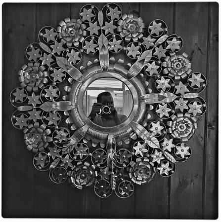 Harry Crosby reflected in ornate tinware mirror