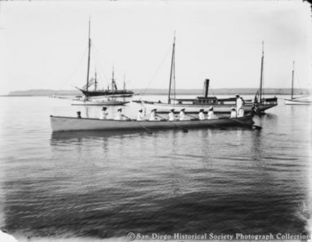View of San Diego Bay showing Zlac Rowing Club boat, steam yacht Dolphin, sloop Restless, and USS Hartford