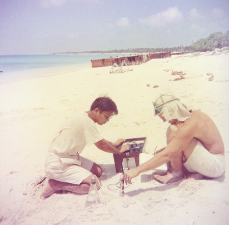 Richard Morita and Robert Dill taking chemical readings ernisticial water in beach sand, Bikini Island