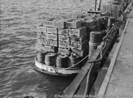 Lobster traps stacked on boat moored to pier