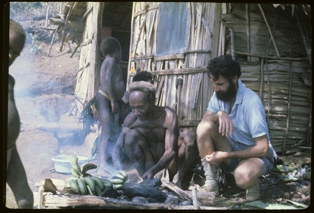 Food preparation: Roy Rappaport observes Muk cooking bananas, Rappaports&#39; house in background