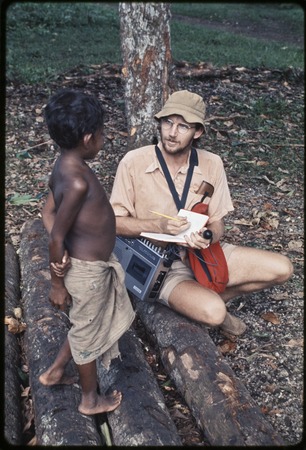 Anthropologist Edwin Hutchins uses tape recorder and takes notes while talking with young child