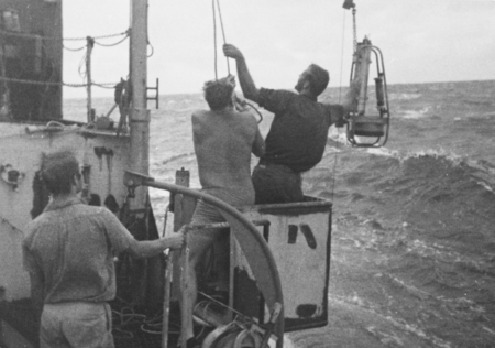 R/V Horizon on Nova Expedition, Leg IV: George Hohnhaus (middle showing back) and Baron E. Thomas with pinger. July 1967