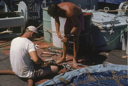 Scientific members of the Swan Song Expedition (1961) are shown here making repairs to the &quot;sampler&quot; water collection bag....