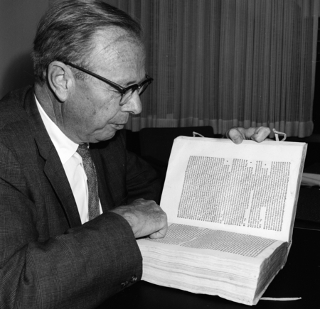 Melvin Voigt examining rare book
