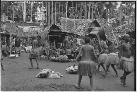 Mortuary ceremony, Omarakana: mourning women make ritual exchange of banana leaf bundles and long fiber skirts