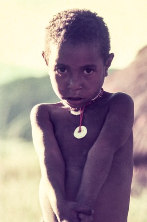 Young girl wearing small shell discs and beads
