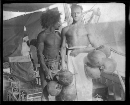 Solomon islander and European man holding coconuts