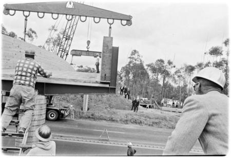 Pedestrian footbridge over U.S. Highway 101 hoisted into place by two cranes