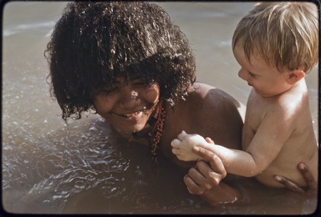 Young woman taking care of an Australian child named Butch Holland, play in water