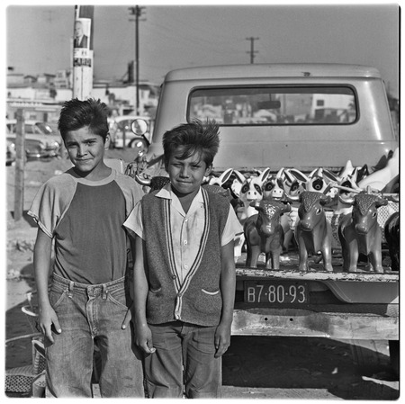 Young sales men with a truckload of plaster burros and bulls