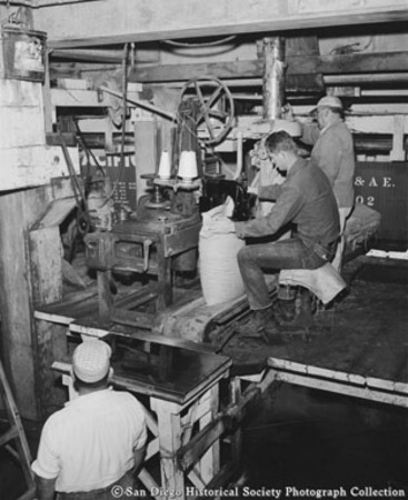 Men packing, weighing, and sewing bags of salt at Western Salt Company, Chula Vista