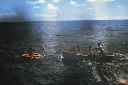 Scientific crew members approaching a buoyed wave recording station during the Capricorn Expedition (1952-1953). 1952.